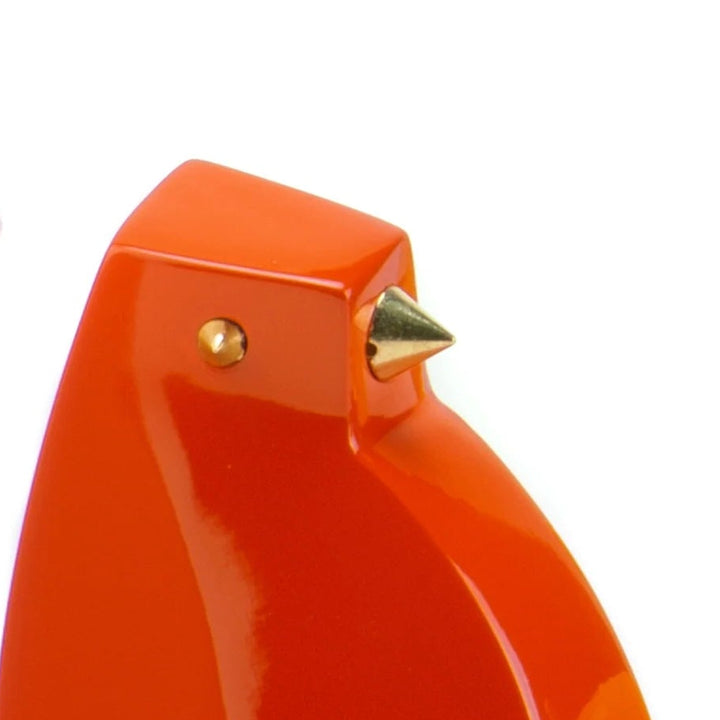 Orange bird-shaped object with gold accents on a white background