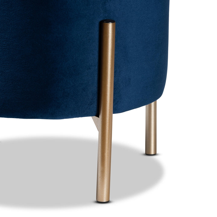 Close-up of a blue upholstered chair with gold metal legs on a white background