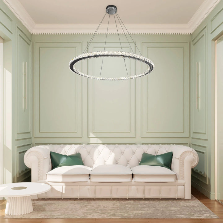 Modern living room with a white sofa, green cushions, and a circular chandelier.