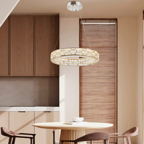 Modern chandelier hanging in a dining room with wooden cabinets and chairs.