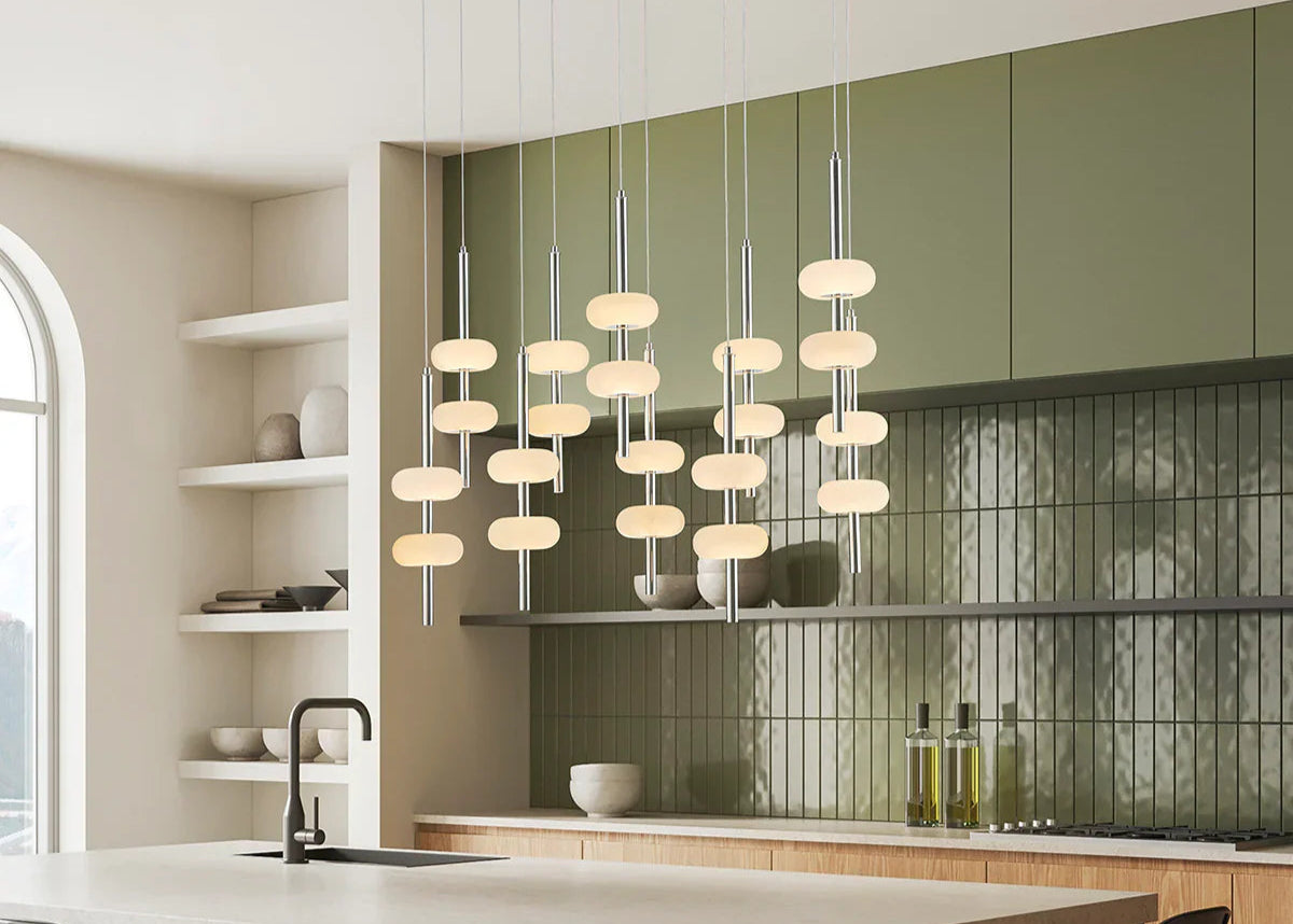 Modern kitchen with pendant lights, green cabinets, and a neutral color scheme.