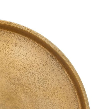 Gold round tray with textured surface on a white background