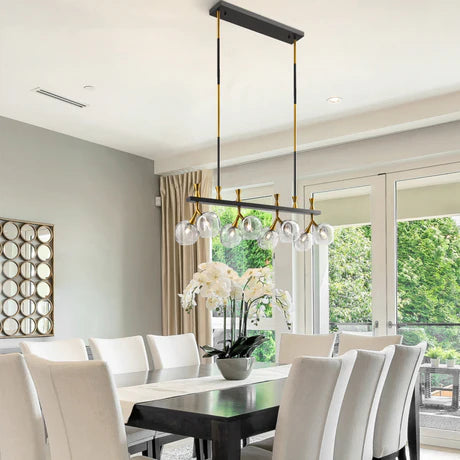 Modern dining room with a stylish chandelier, white chairs, and a large window.