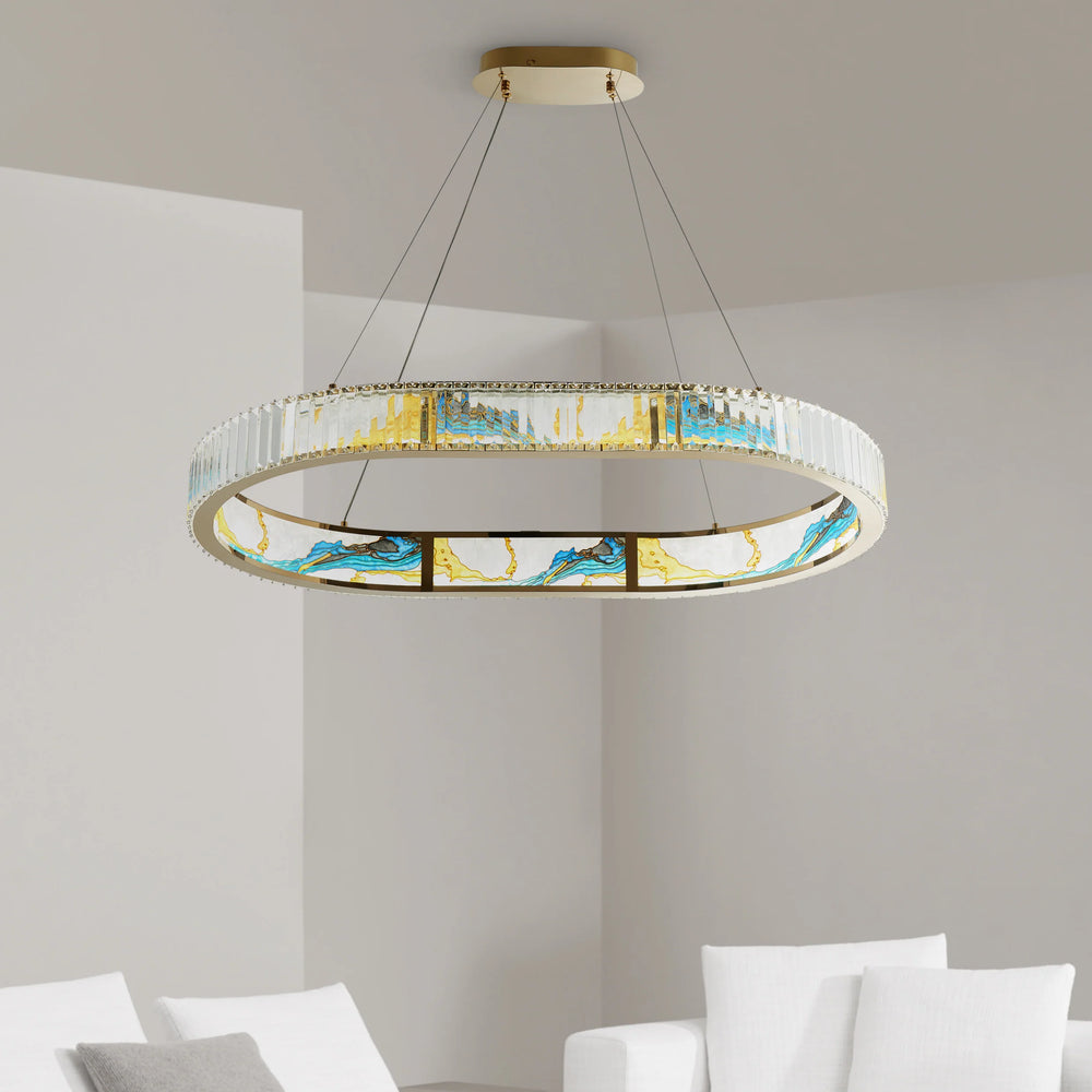 Modern chandelier with colorful glass panels in a room with white walls and furniture.