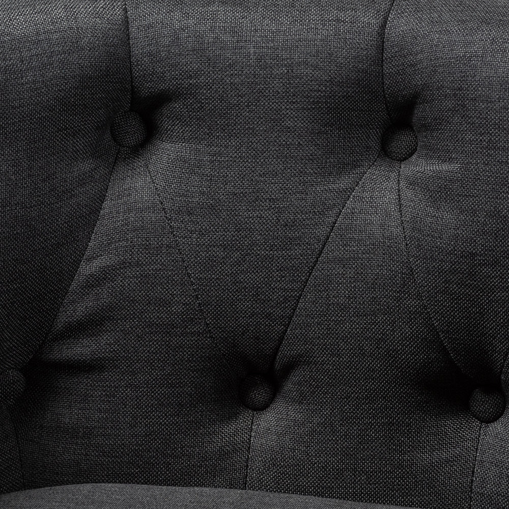 Close-up of a dark gray upholstered chair with tufted backrest