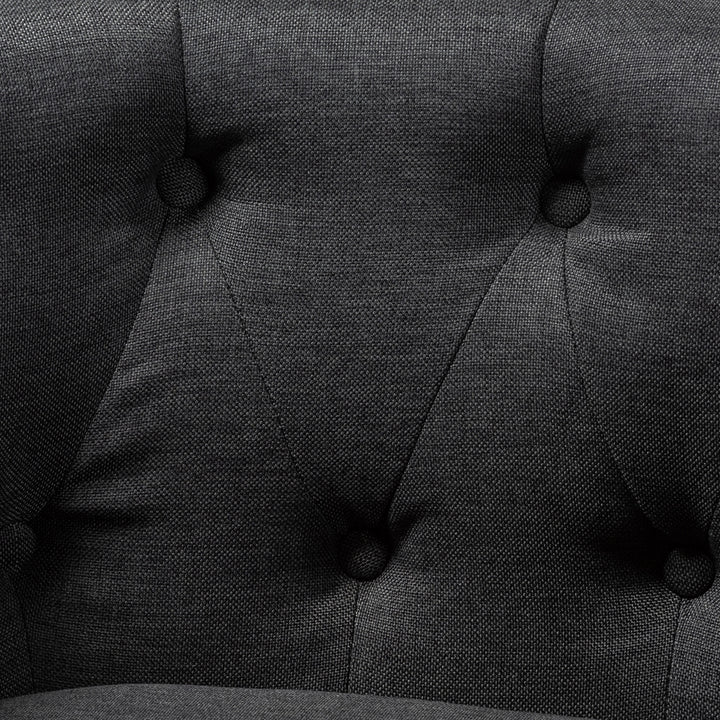 Close-up of a dark gray upholstered chair with tufted backrest
