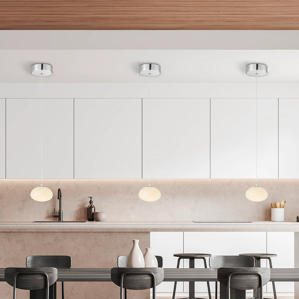 Modern kitchen with white cabinets, a countertop, and pendant lights.