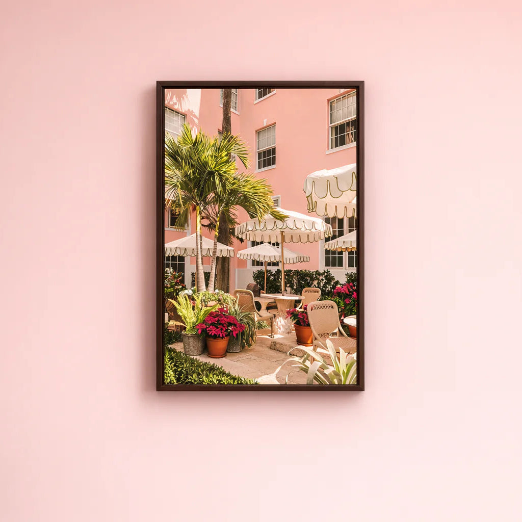 Framed photograph of an outdoor cafe scene with a pink building on a pink wall.