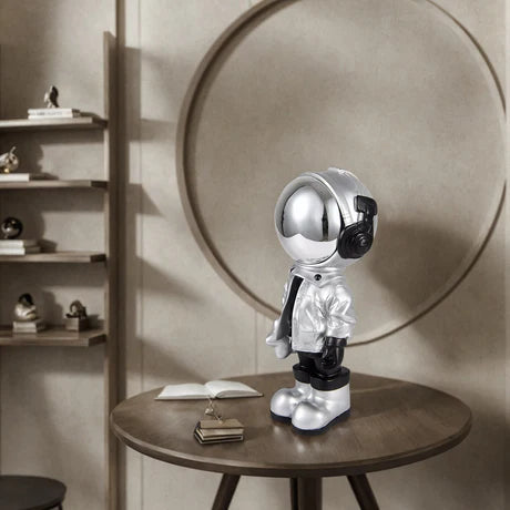 Silver astronaut figurine on a wooden table with a neutral background