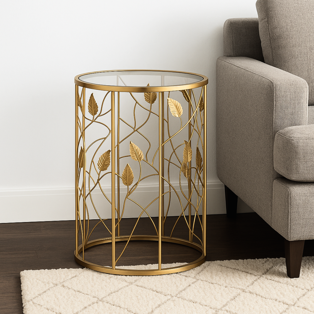 Gold leaf-patterned side table next to a gray sofa in a room with wooden flooring and white walls.