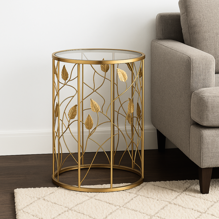 Gold leaf-patterned side table next to a gray sofa in a room with wooden flooring and white walls.