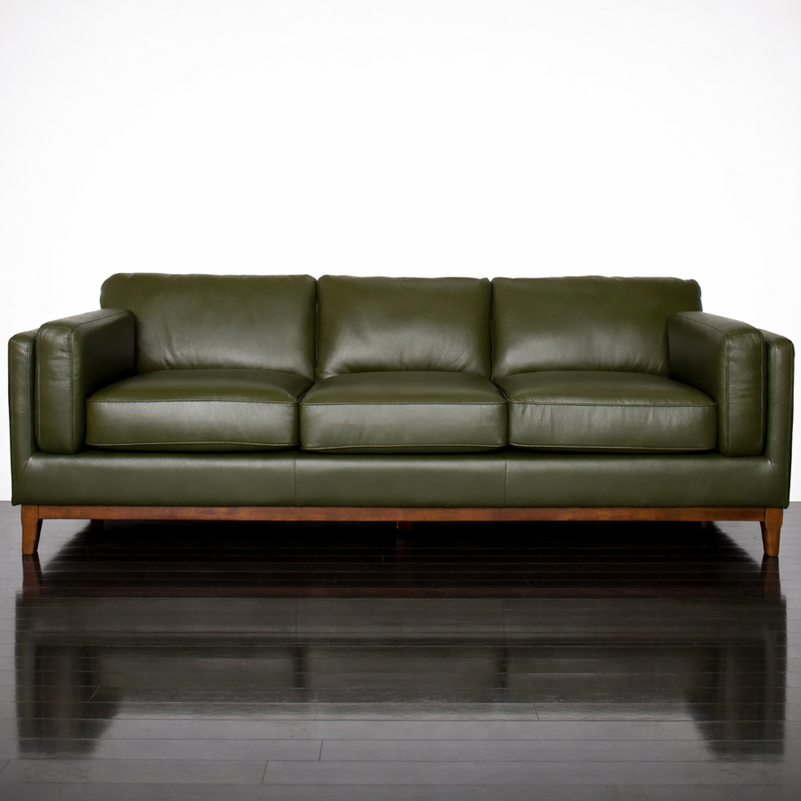 Green leather sofa on a reflective surface with a white background