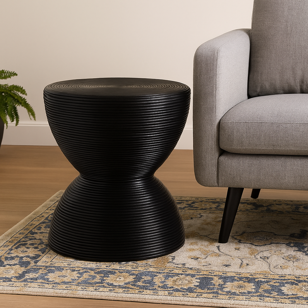 Handcrafted from natural rattan and finished in sleek black, the Tokyo Side Table blends traditional craftsmanship with modern sculptural design. Its hourglass silhouette, made from tightly coiled rattan, adds texture and visual depth to any room. Perfect as a statement accent or functional surface beside a sofa or bed, this piece brings warmth, durability, and timeless style.