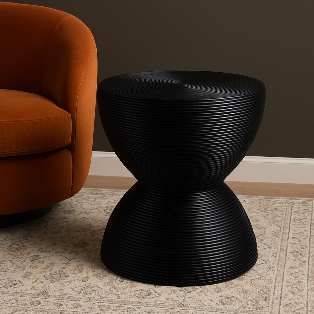 Handcrafted from natural rattan and finished in sleek black, the Tokyo Side Table blends traditional craftsmanship with modern sculptural design. Its hourglass silhouette, made from tightly coiled rattan, adds texture and visual depth to any room. Perfect as a statement accent or functional surface beside a sofa or bed, this piece brings warmth, durability, and timeless style.