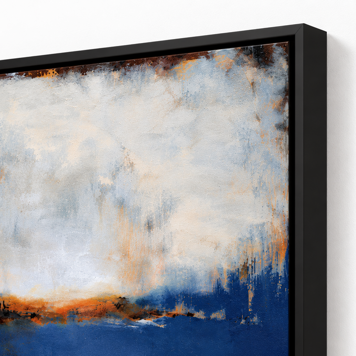 Abstract framed wall art featuring textured brushstrokes in blue, white, gray, and warm orange-brown tones, shown at an angle with a black frame against a white wall.   