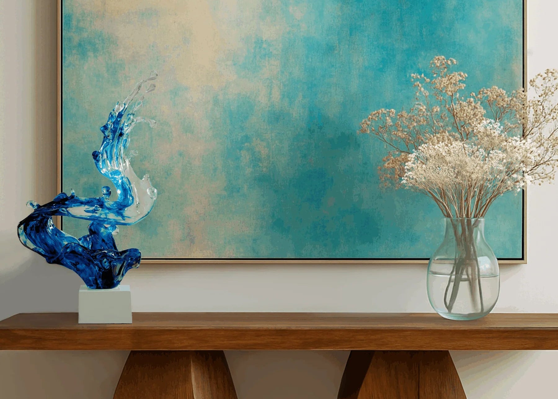 Decorative setup with a blue abstract sculpture, clear vase with flowers, and abstract painting on a wall.
