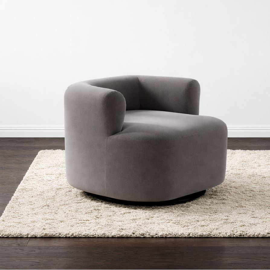 Gray armchair on a beige rug with a white wall background 
