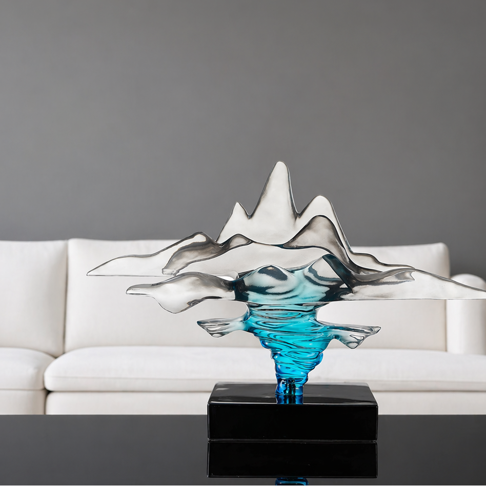 Decorative glass sculpture on a black base in front of a white sofa against a gray wall