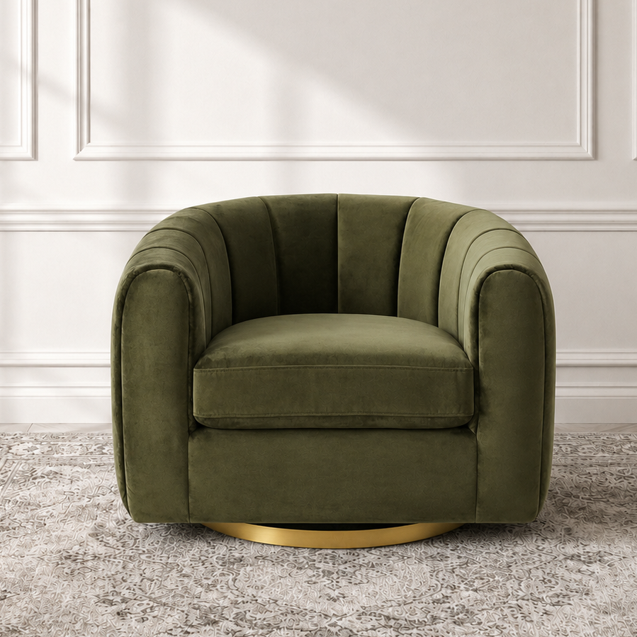 An olive green velvet swivel armchair with a gold metal base, positioned on a distressed gray patterned rug against a white paneled wall.