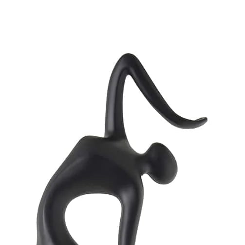Black abstract sculpture of a dancer on a white background