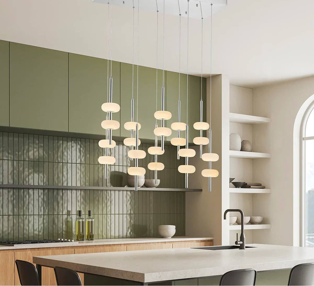 Modern kitchen with pendant lights, green cabinets, and a neutral color scheme.