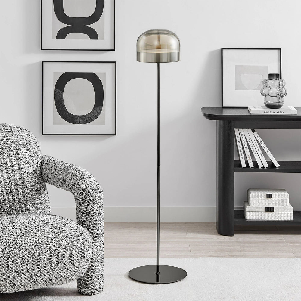 Modern living room with a floor lamp, armchair, and bookshelf.