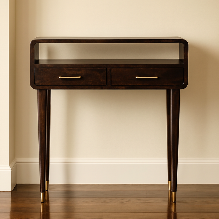 Wooden console table with two drawers and gold handles against a beige wall.