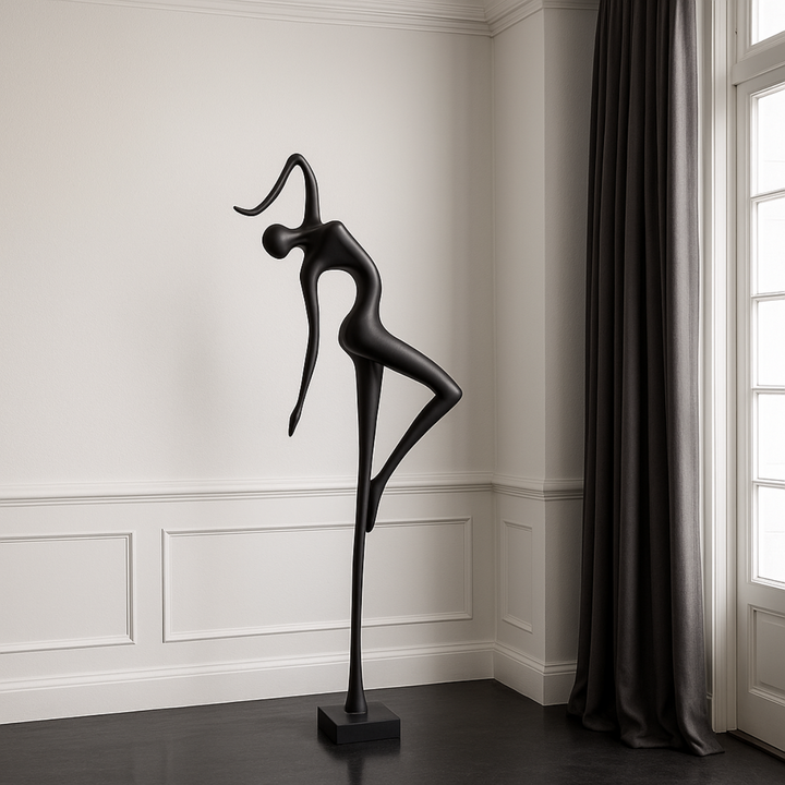 Black abstract sculpture of a dancer in a room with white walls and a window.