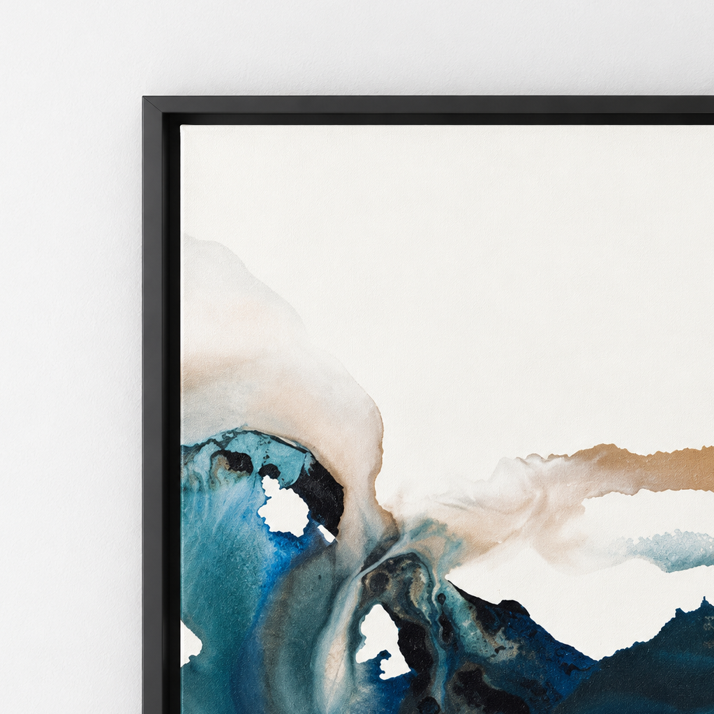A close-up of a framed abstract wall art print hanging on a white wall. The artwork features flowing watercolor-like forms in deep blue, teal, cream, and tan, enclosed in a slim black frame.  