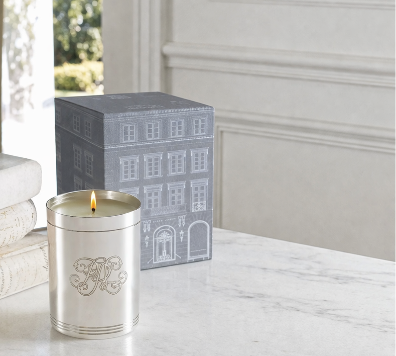 Candle on a marble table with books and a decorative box in the background