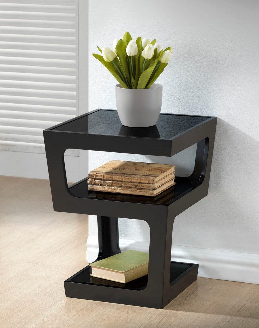Black side table with a white pot of tulips and books on a light wood floor.