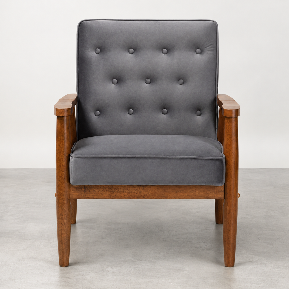 A mid-century modern armchair with a dark gray tufted velvet cushion and a warm brown wooden frame, shown against a neutral gray studio background.