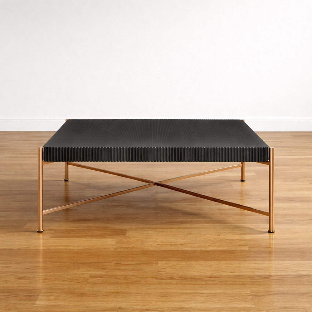 Modern coffee table with black top and gold frame on a wooden floor. 
