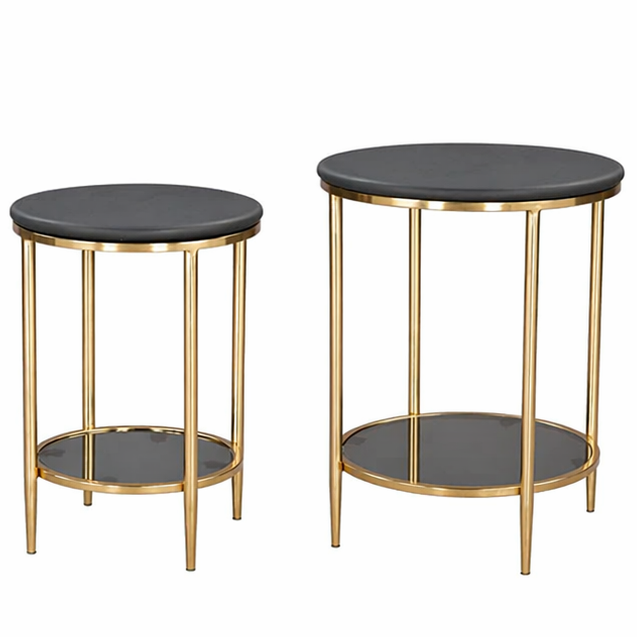 Two round side tables with black marble tops and gold metal frames on a white background. 