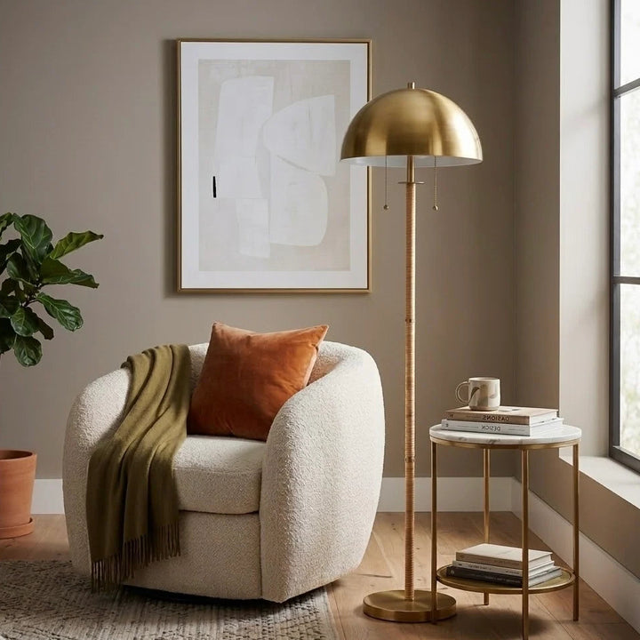 Cozy living room with a beige armchair, gold floor lamp, and abstract art on the wall.