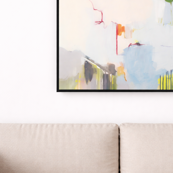 Framed abstract artwork on a wall above a beige sofa