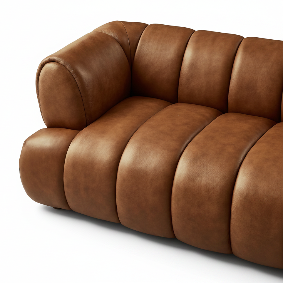 Brown leather sofa in a room with a window and curtain.