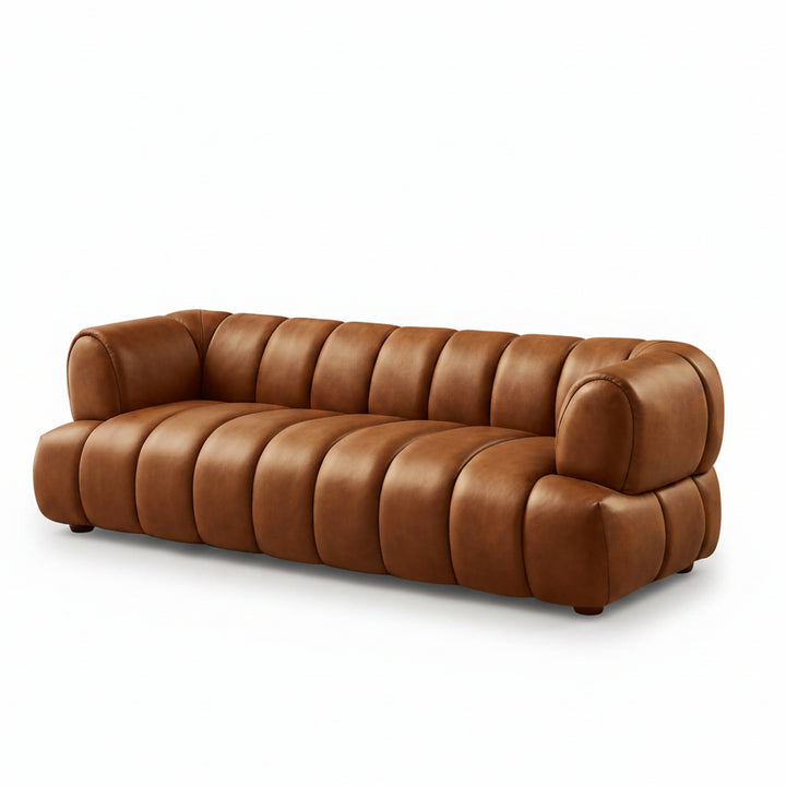Brown leather sofa in a modern living room with a coffee table and laptop.