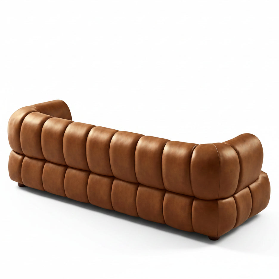 Brown leather sofa in a room with a large window and wall art.