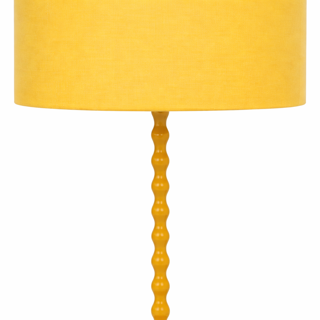 Yellow table lamp with a textured base on a white background