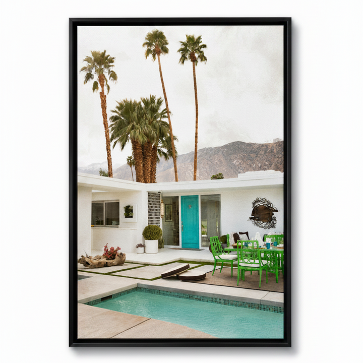 Framed photograph of a poolside scene with palm trees and a house.