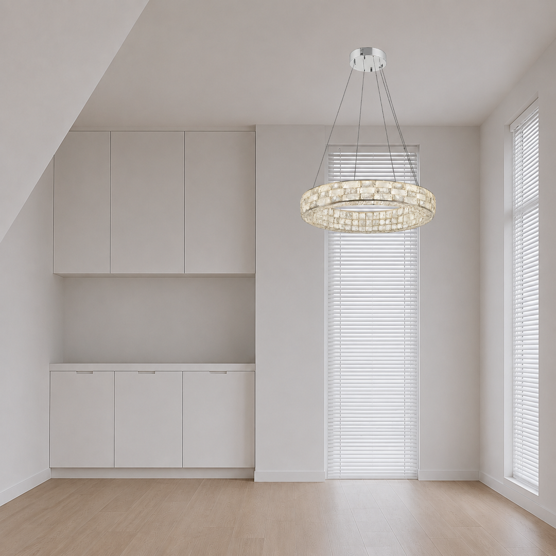 Bright minimalist room with soft, even natural light filtered through white blinds, creating gentle shadows across pale walls, built-in white cabinets, and light wood flooring. A large circular crystal chandelier hangs near the windows, adding a warm glow while the room remains clean, neutral, and crisp.